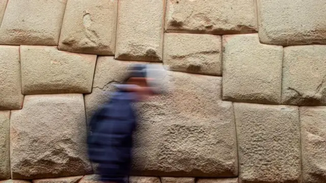 Um homem passando pela pedra dos 12 ângulos